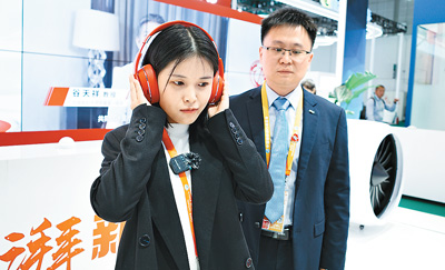 图为记者在展台工作人员的指导下进行互动体验。本报记者 徐佩玉摄