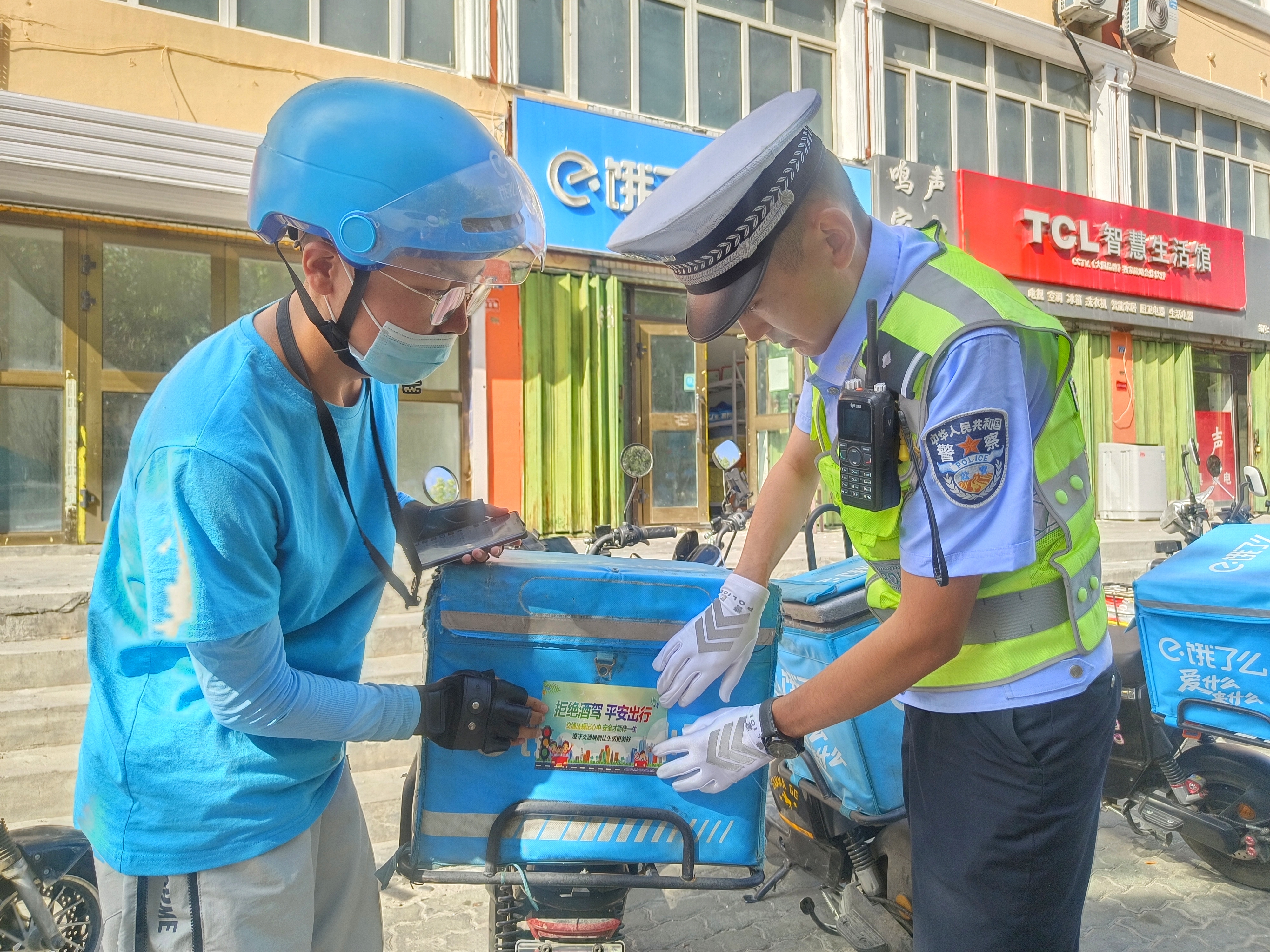 民警为外卖骑手张贴拒绝酒驾 平安出行宣传标语.jpg