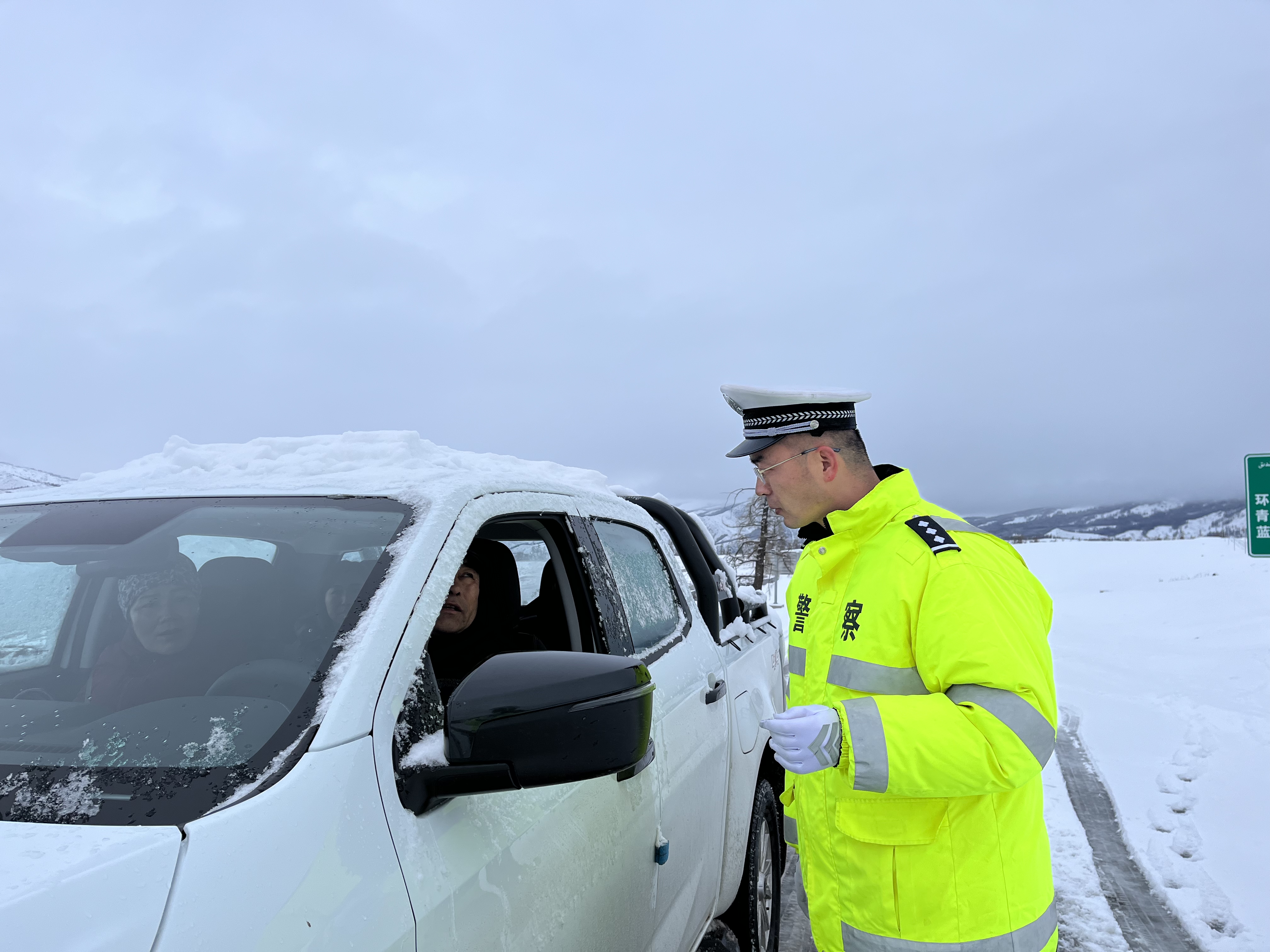 执勤民警提醒过往车辆注意减速慢行 确保行车安全.jpg